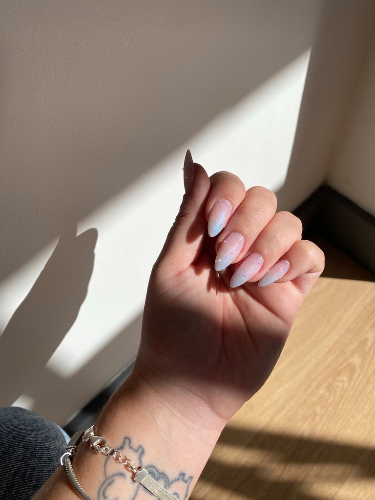Fotografia de exemplo: unhas de gel com brilho pastel ao sol